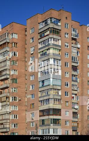 Detailliertes Foto eines mehrstöckigen Wohngebäudes mit vielen Balkonen und Fenstern. Jugendherbergen für arme Menschen in Russland und der Ukraine in einem beschädigt Stockfoto