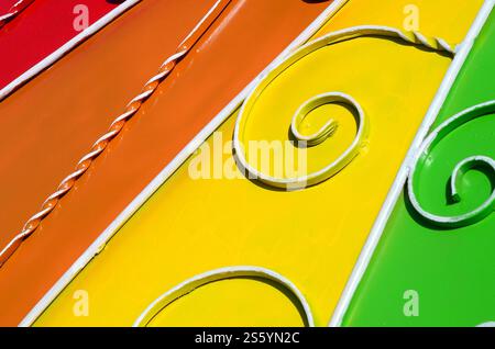 Metallstruktur eines Stücks farbiger Wand mit geschmiedetem Muster. Regenbogenfarben. Metallstruktur eines Stücks farbiger Wand mit geschmiedetem Muster Stockfoto
