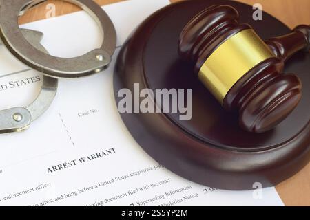 Justizhammer und Haftbefehl, Blankodokument mit Polizeihandschellen aus nächster Nähe. Justizhammer und Haftbefehl geben ein unbeschreibliches Dokument mit der Polizei Stockfoto