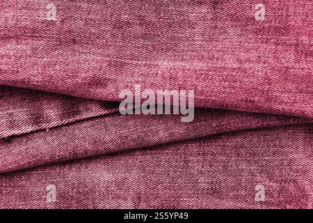 Detaillierte abstrakte Textur aus dunkelblauem Denimstoff. Hintergrundbild des alten gebrauchten Denim-Hosenstoffes Nahaufnahme Bild getönt in Viva Magenta, Farbe von Stockfoto