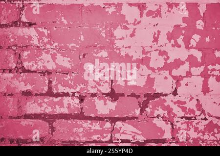 Die Textur einer sehr alten Ziegelwand mit einer abblätternden und rauen Lackschicht, die sich aufgrund des Alters und der Feuchtigkeit zersetzt Stockfoto