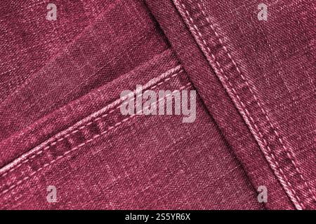 Detaillierte abstrakte Textur aus dunkelblauem Denimstoff. Hintergrundbild des alten gebrauchten Denim-Hosenstoffes Nahaufnahme Bild getönt in Viva Magenta, Farbe von Stockfoto