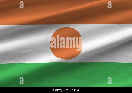 Niger-Flagge mit großen Falten, die dicht oben unter dem Studio-Licht winken. Die offiziellen Symbole und Farben im Stoffbanner. Niger-Flagge mit großen Falten Stockfoto