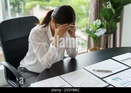 Burnout-Konzept. Asiatische Geschäftsfrau, die die Stirn berührt, Kopfschmerzen, langweilige Arbeit und müde emotionale Schmerzen und professionelle Person depressiv über Stockfoto