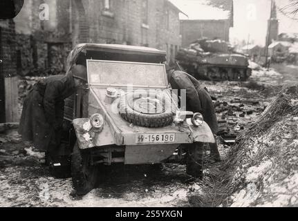 Verlassene Kubelwagen aus der 2. SS-Panzerdivision - das Reich - in Beffe, Belgien. Im Hintergrund ein amerikanischer Panzer M4A3 (76) W Sherman. Januar 1945. - Historisches Dokument, Fotograf unbekannt Stockfoto