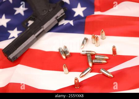 Viele gelbe 9-mm-Kugeln und Geschütze auf US-Flagge. Konzept des Waffenhandels auf US-Territorium oder US-Schießstand. Viele gelbe 9-mm-Kugeln und Stockfoto