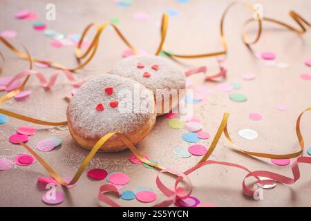 Farbenfroher Karneval- oder Partyhintergrund mit Donuts, Streamer und Konfetti Stockfoto