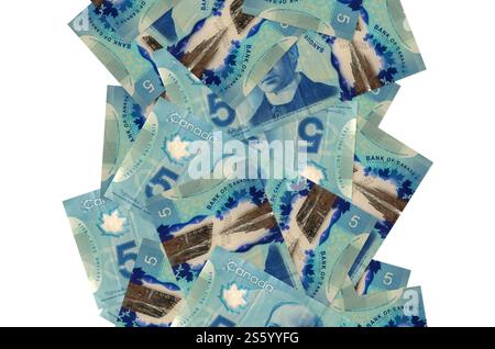 5 kanadische Dollarscheine fliegen isoliert auf weiß herunter. Viele Banknoten fallen mit weißem Kopierraum auf der linken und rechten Seite. 5 kanadische Dollar-Scheine Stockfoto
