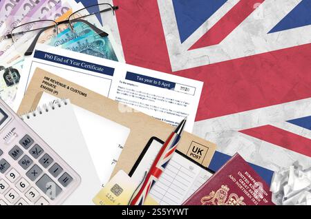 Englisch Steuerformular P60 Jahresabschluss-Zertifikat von HM Income and Customs liegt mit Büroartikeln auf dem Tisch. HMRC-Papiere und Steuerzahlungsprozess in Stockfoto