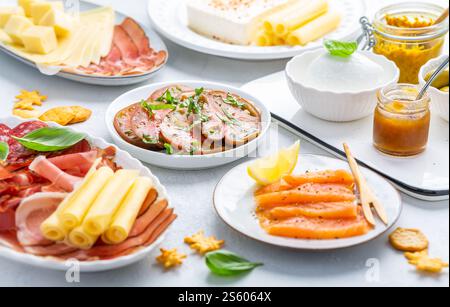 Verschiedene Vorspeisen für Brunch oder Party mit Lachs, Käse, Salami und Gemüse Stockfoto