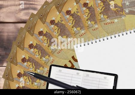 Fächer für 50 Euro-Scheine und Notizblock mit Kontaktbuch und schwarzem Stift. Konzept der Finanzplanung und Geschäftsstrategie. Buchhaltung und Investitionen. 50 Stockfoto