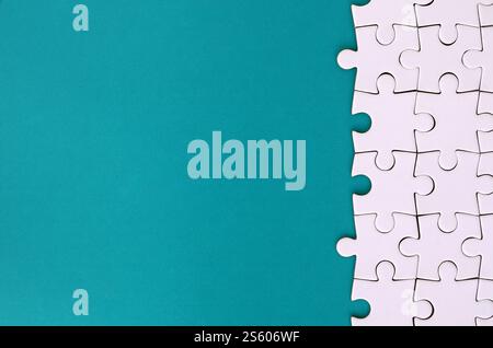 Fragment eines gefalteten weißen Puzzle auf dem Hintergrund einer blauen Kunststoff Oberfläche. Textur Foto mit Platz für Text kopieren Stockfoto
