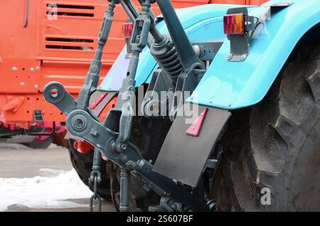 Räder der Rückansicht des neuen Traktors bei Schnee. Rückansicht des landwirtschaftlichen Fahrzeugs. Räder der Rückansicht des neuen Traktors bei Schnee. Stockfoto