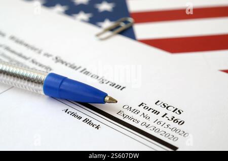I-360 Petition für Amerasian-, Witwer- oder spezielle Einwanderungsformulare liegt auf der Flagge der Vereinigten Staaten mit blauem Stift vom Department of Homeland Security Stockfoto