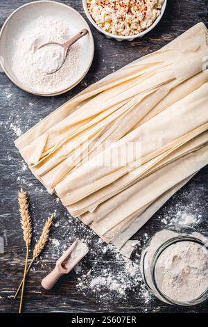 Roher Phyllo-Teig mit Fetakäse, zum Füllen zubereitet, pikante Teigwaren, Filo-Teig Stockfoto