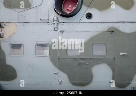 Seitenteile eines Militärhubschraubers in Tarnfarbe. Alte gepanzerte Flugzeuge aus der Nähe. Seitenteile Textur des Militärhubschraubers eingestrichen Stockfoto
