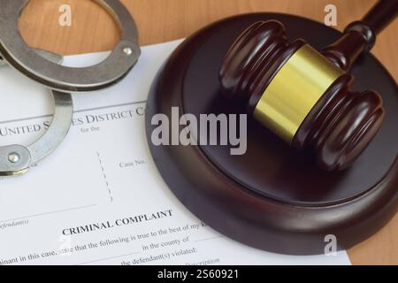 Justizhammer und Strafanzeige leeres Dokument mit Polizeihandschellen aus nächster Nähe. Justizhammer und Strafanzeige bei der Polizei Stockfoto