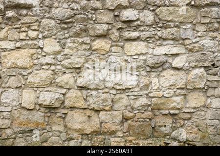 Textur einer Steinmauer mit vielen großen braunen und grauen Steinen, die mit Zement bewaffnet sind. Alte Burg Stein Wand Textur Hintergrund für mittelalterliche Nutzung. Teil eines Stockfoto