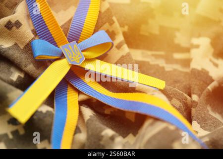 Gepixelter digitaler Militärtarnstoff mit ukrainischer Flagge und Wappen auf Streifenband in blauen und gelben Farben. Attribute von ukrainisch Stockfoto