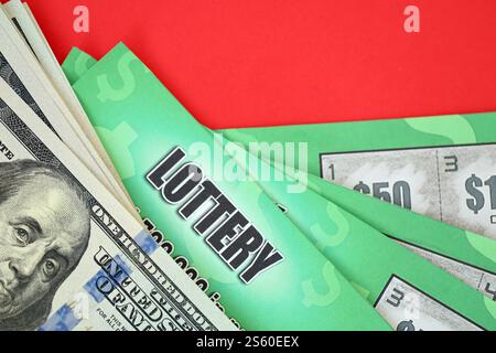 Nahaufnahme von grünen Lotterie-Rubbelkarten und US-Dollarscheinen. Viele haben gefälschte Lotterielos mit Glücksspielergebnissen verwendet. Spielsucht Stockfoto