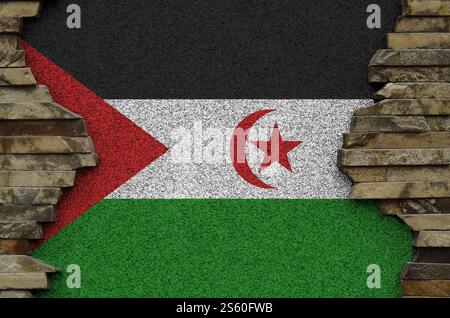 Westsahara-Flagge in Malfarben auf der alten Steinmauer aus nächster Nähe dargestellt. Strukturiertes Banner auf Steinwand Hintergrund. Westsahara-Flagge abgebildet in Stockfoto