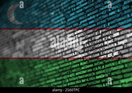 Die Flagge Usbekistans wird auf dem Bildschirm mit dem Programmcode dargestellt. Das Konzept der modernen Technik und der Standortentwicklung. Die Flagge Usbekistans ist abgebildet Stockfoto