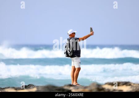 Mann macht Selfie gegen raues Meer, El Cotillo, Fuerteventura, Kanarische Inseln, Spanien. Stockfoto