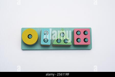 Ein Puzzlespiel aus Holzfiguren verschiedener Formen auf weißem Hintergrund. Stockfoto