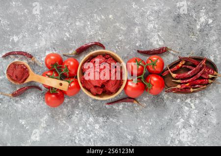 Traditioneller türkischer Chili-Pfeffer und Tomatenpaste in einer Schüssel oder einem Löffel mit getrockneten Paprika und frischen Tomaten auf dem Tisch Stockfoto