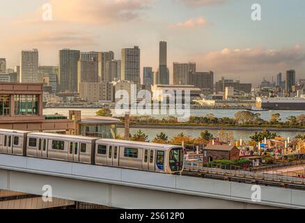 Tokyo Yurikamome Monorail Zug bei Odaiba mit der Tokyo Skyline im Hintergrund, Japan Stockfoto