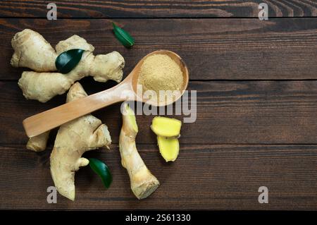 Frisch gehackte Ingwerwurzel und gemahlenes Ingwerpulver im Holzlöffel auf rustikalem Holztisch. Gesundes Essen, Gewürz. Zingiber officinale Stockfoto