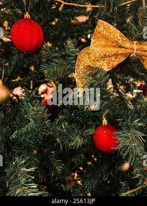 Weihnachtsbaum mit Dekoration, roter Schleife und goldener Kugel Stockfoto