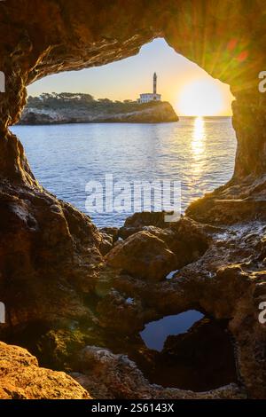 Der Leuchtturm von Portocolom auf der Insel Mallorca kann durch ein Loch im Felsen, Spanien, gesehen werden Stockfoto