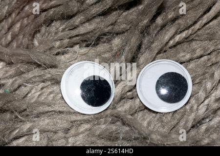 Lustiges Wiggle Google Eyes auf Stoff dumm Pelz Hintergrund Stockfoto