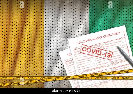 Flagge der Elfenbeinküste und Antragsformular für die Krankenversicherung mit covid-19-Stempel. Coronavirus oder pandemisches 2019-nCoV-Viruskonzept. Elfenbeinküste Flagge und Gesundheit Stockfoto
