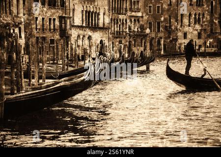 Venedig (Italien). Gondelbahn mit nicht erkennbarem Gondoliere, Abfahrt vom Pier. Foto im Retro-Alter mit Kratzern. Stockfoto