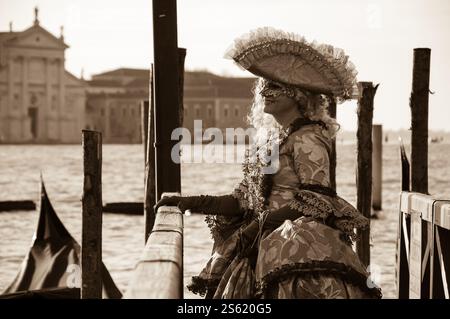 VENEDIG, ITALIEN - 16. FEBRUAR 2015: Maske auf dem Markusplatz (mit Blick auf die Insel San Giorgio Maggiore) während des Karnevals. Sepia-Foto Stockfoto