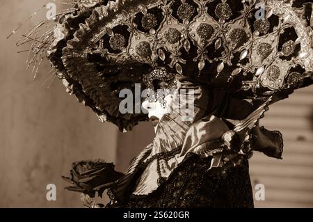 VENEDIG, ITALIEN - 16. FEBRUAR 2015: Romantische Maske mit einer Rose auf dem Markusplatz während des Karnevals. Der Karneval in Venedig ist ein jährliches Ereignis Stockfoto