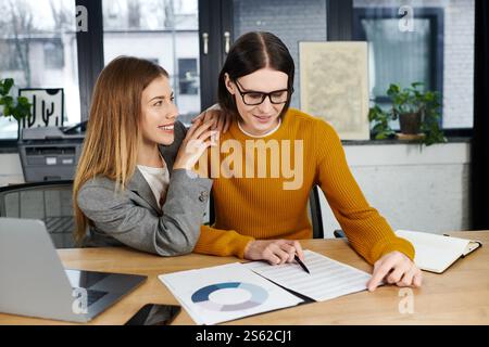 Zwei junge Menschen arbeiten an einem stilvollen Arbeitsplatz kreativ zusammen und tauschen ihre Ideen aus. Stockfoto