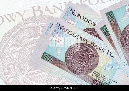10 polnische Zloty-Scheine liegen im Stapel auf dem Hintergrund großer halbtransparenter Banknoten. Abstrakte Darstellung der Landeswährung. Geschäftskonzept. 10 Stockfoto