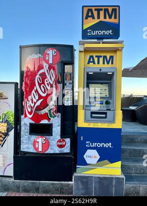 Coca-Cola-Automat und Euronet-Geldautomat an der Küste von Costa Adeje bei Playa de Fanabe. Teneriffa, Kanarische Inseln, Spanien. Januar 2025. Stockfoto