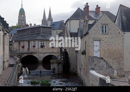 Blick auf eine alte Bayeux Mühle am Fluss Aure, mit dem Touristenbüro und der Kathedrale im Hintergrund, mittelalterliche Stadt Bayeux, Normandie, Frankreich Stockfoto