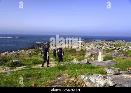 Gruppe von Personen auf dem Weg nach santiago de compostela, die entlang der Küstenstraße laufen Stockfoto