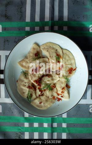 Varenyky oder Teigtaschen mit gebratenen Zwiebeln und Dill, serviert auf weißem Teller Stockfoto