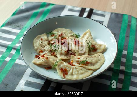Varenyky oder Knödel mit gebratenen Zwiebeln und Dill serviert auf einem Teller Stockfoto