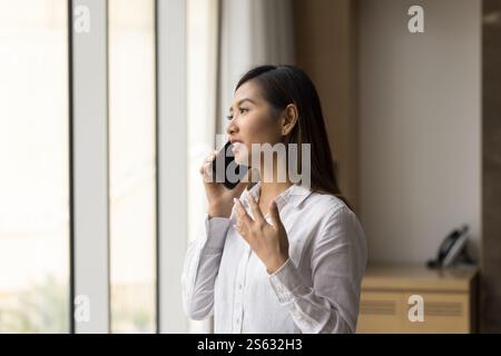 Junge attraktive asiatische Geschäftsfrau, die auf dem Handy spricht Stockfoto