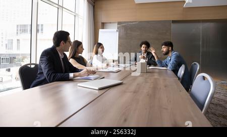 Millennial multinationale Mitarbeiter hören jungen arabischen Teamkollegen zu Stockfoto