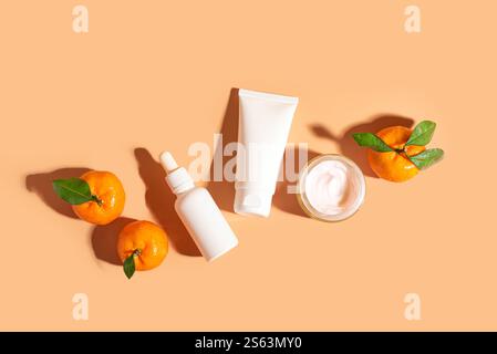 Natürliches Vitamin-C-Serum und Gesichtscreme, Hautpflege, ätherische Öle. Kosmetische Produkte und frische saftige Zitrusfrüchte auf orangenem Hintergrund, Creati Stockfoto