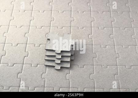 Graue Puzzleteile in einer kleinen Reihe. Auf einem Puzzle-Papphintergrund. Stockfoto