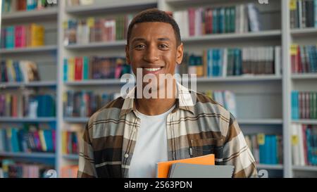 Erfolgreicher glücklicher afroamerikanischer Mann Student männliche Bibliothek Lehrbücher Zahnzahnarzt Lächeln Lerner-Studium vermitteln Schüler Guy High School Wissen Stockfoto
